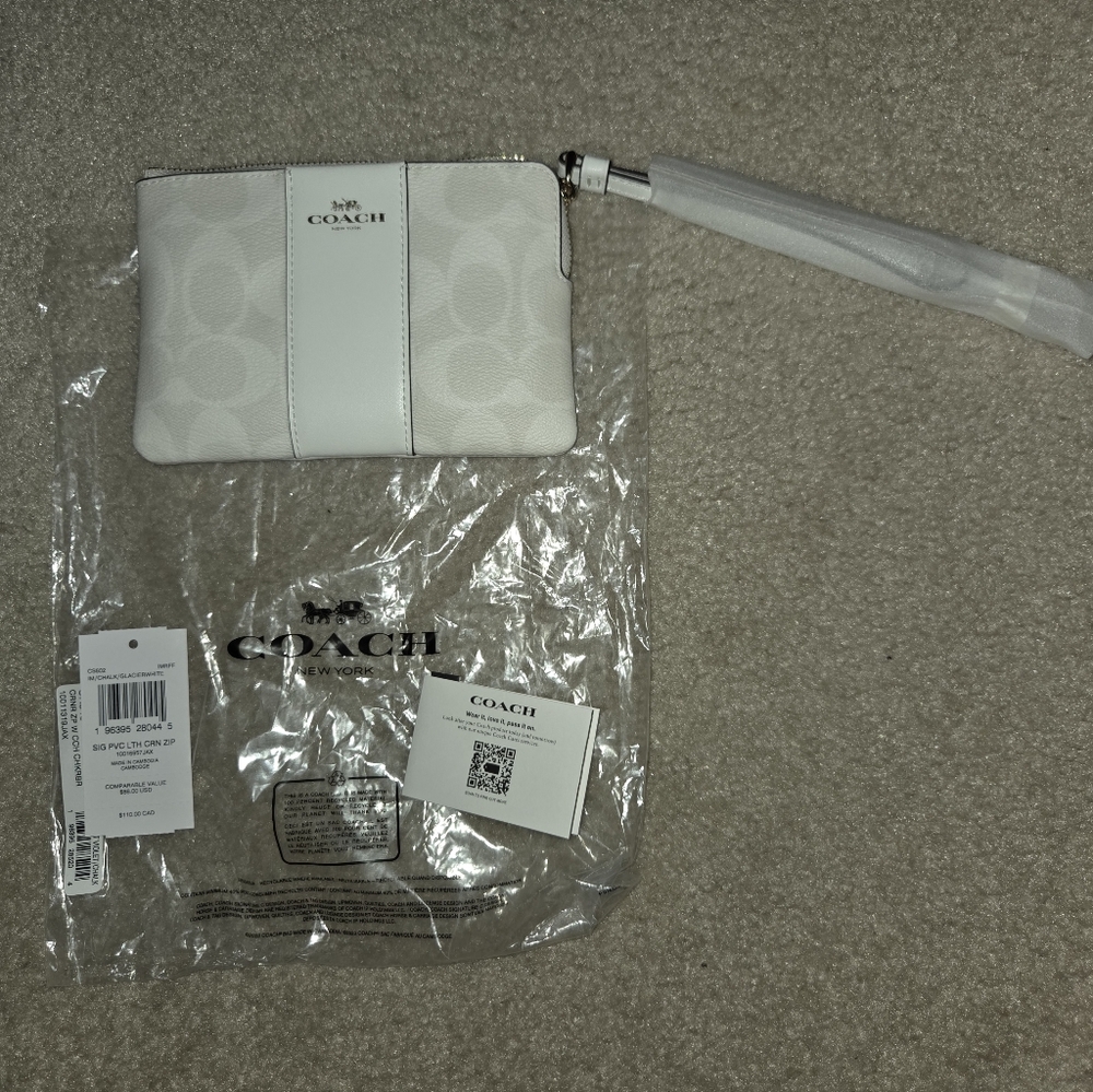 Coach corner white zip wristlet in signature canvas. This color will stand out.